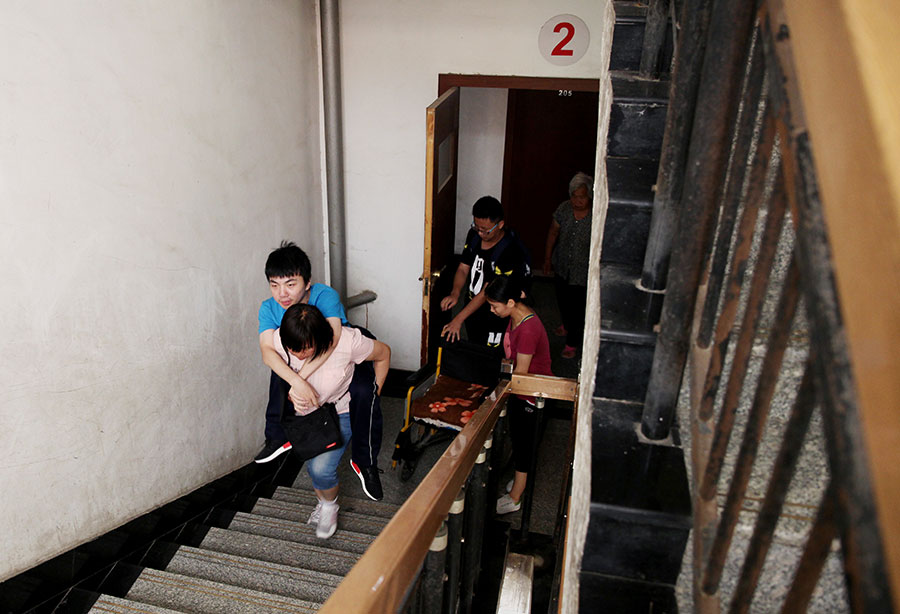 La madre de Zhu Zhiqiang lleva a su hijo a la planta superior, el 8 de julio de 2016.