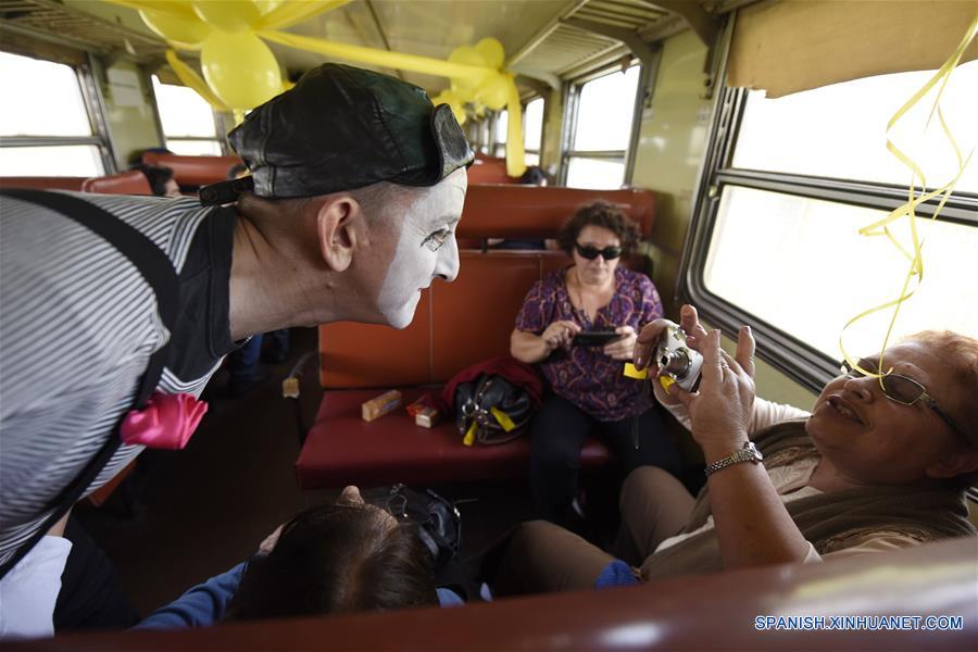 Un artista entretiene a residentes del pueblo San Bautista durante el viaje en tren hacia Montevideo para participar en el evento "Un Pueblo al Solís", en San Bautista, Uruguay, el 19 de noviembre de 2016. De acuerdo con información de la prensa local, "Un Pueblo al Solís" es una iniciativa que consiste en trasladar a público procedente del interior del país a presenciar espectáculos en el Teatro Solís, y es un esfuerzo en conjunto del Ministerio de Educación y Cultura, la Intendencia de Montevideo a través de su Departamento de Cultura y el Teatro Solís. (Xinhua/Nicolás Celaya)