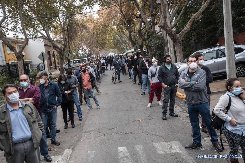 Personas esperan en una fila para emitir su voto en un centro de votación durante las elecciones de alcaldes, concejales, gobernadores regionales y convencionales constituyentes, en Santiago, capital de Chile, el 15 de mayo de 2021. Chile celebra este fin de semana una jornada histórica de elecciones, en las que 14,9 millones de votantes escogerán alcaldes, concejales y por primera vez gobernadores regionales y convencionales constituyentes, bajo estrictas medidas para evitar los contagios de la enfermedad del nuevo coronavirus (COVID-19). (Xinhua/Jorge Villegas)
