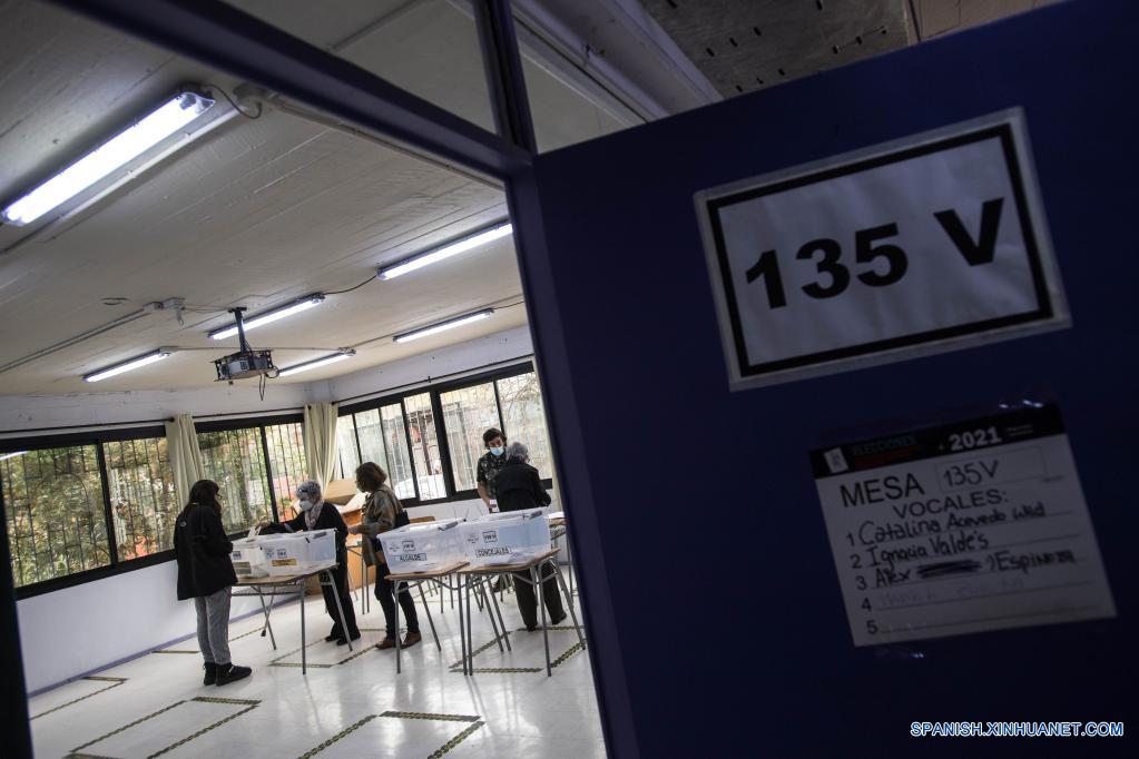 Una mujer emite su voto en un centro de votación durante las elecciones de alcaldes, concejales, gobernadores regionales y convencionales constituyentes, en Santiago, capital de Chile, el 15 de mayo de 2021. Chile celebra este fin de semana una jornada histórica de elecciones, en las que 14,9 millones de votantes escogerán alcaldes, concejales y por primera vez gobernadores regionales y convencionales constituyentes, bajo estrictas medidas para evitar los contagios de la enfermedad del nuevo coronavirus (COVID-19). (Xinhua/Jorge Villegas)