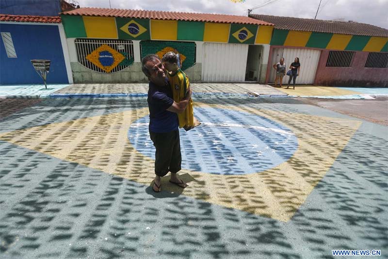 n hombre sostiene un mu?eco que porta la camiseta de la selección nacional de fútbol de Brasil en una calle decorada con motivo de la participación de la selección brasile?a en la Copa Mundial de la FIFA Qatar 2022, en Brasilia, Brasil, el 16 de noviembre de 2022. (Xinhua/Lucio Tavora) 