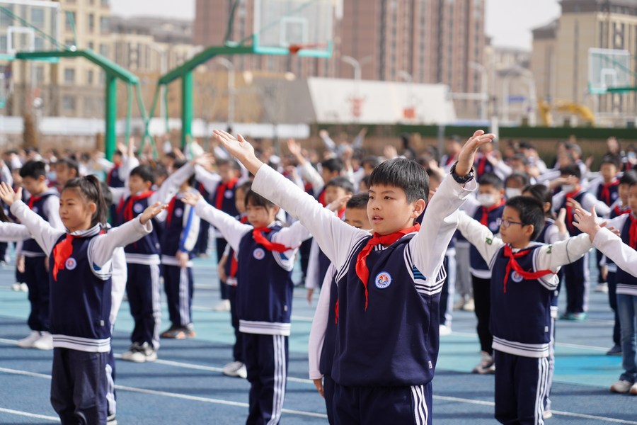 Ni?os hacen ejercicios en el campo deportivo de la escuela primaria Yunxi, en la Nueva área de Xiong'an, ubicada en la provincia septentrional china de Hebei, el 23 del marzo de 2023. (Xinhua/Mu Yu)