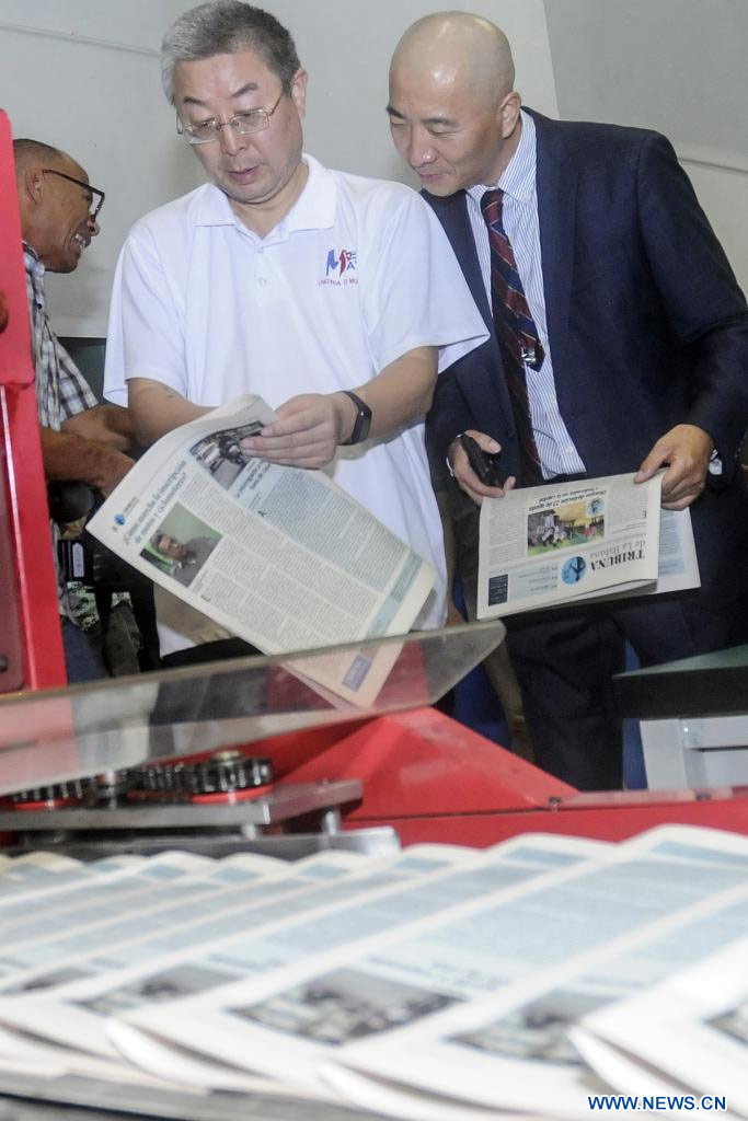 Imagen del 19 de agosto de 2023 del embajador chino en Cuba, Ma Hui (i), observando un periódico en su visita al proyecto de reconversión tecnológica para la producción de la prensa y otros materiales gráficos en Cuba, en La Habana, capital de Cuba. Cuba moderniza hoy la industria poligráfica, con un crédito otorgado a través del Banco de Exportación e Importación de China, que ha permitido mejorar el equipamiento y acelerar los procesos de impresión y distribución en la isla caribe?a. (Xinhua/Str) 