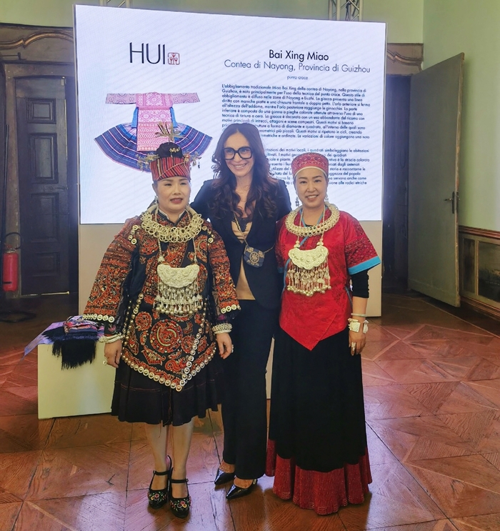 Barbara Mazzali, concejala de turismo, moda y marketing territorial de la región italiana de Lombardía, posa con dos bordadoras de la provincia de Guizhou en un desfile inspirado en el bordado Miao del dise?ador chino Zhao Huizhou el domingo durante la Semana de la Moda de Milán. [Foto proporcionada a chinadaily.com.cn]