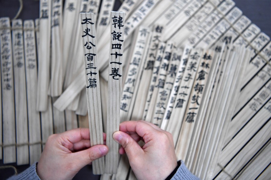 Un empleado del Museo de Jiandu de Gansu organiza obras de "Jiandu" hechas por él mismo en Lanzhou, capital de la provincia noroccidental china de Gansu, el 25 de octubre de 2023. "Jiandu" son tablillas de bambú y madera en que los antiguos chinos escribían, usando tinta y pinceles, antes de la invención del papel. (Xinhua/Chen Bin)
