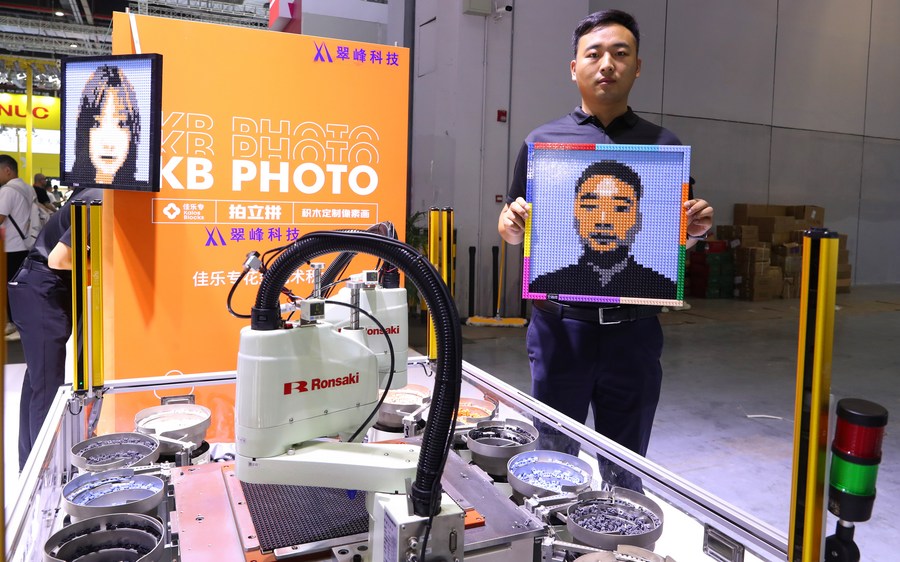 Un trabajador muestra su retrato hecho en bloques durante la 23a Feria Internacional de la Industria de China (CIIF, por sus siglas en inglés), en Shanghai, en el este de China, el 19 de septiembre de 2023. (Xinhua/Fang Zhe)