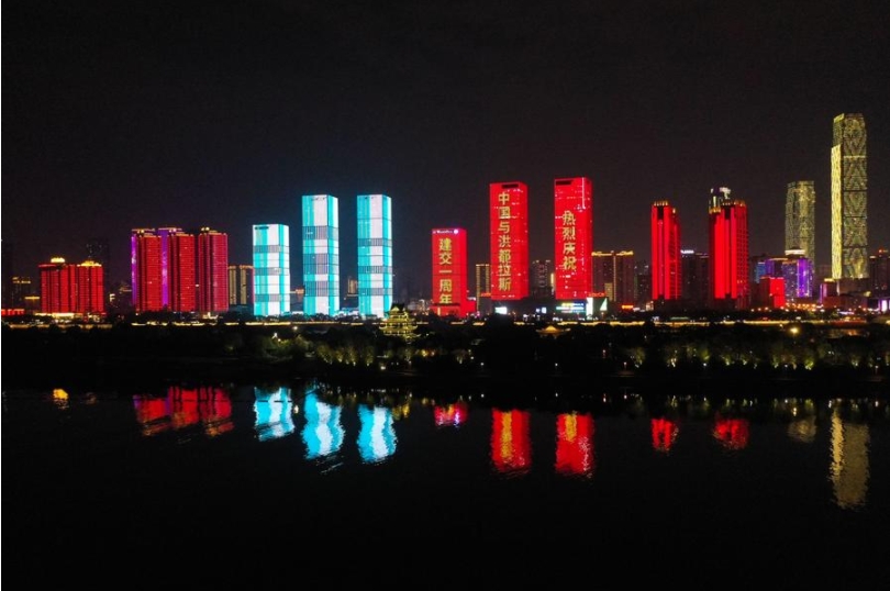 Vista panorámica de una hilera de edificios a lo largo del río Xiangjiang iluminados para celebrar el primer aniversario del establecimiento de relaciones diplomáticas entre China y Honduras, en Changsha, capital de la provincia central china de Hunan, el 26 de marzo de 2024. (Xinhua/Xue Yuge)