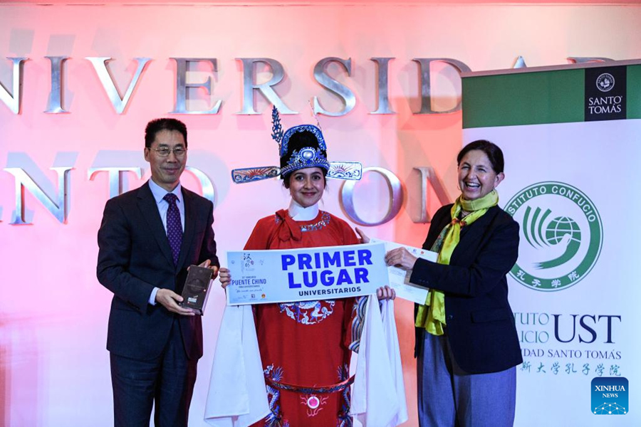 La estudiante Carolina Herrera (c), del instituto Duoc UC (Departamento Universitario Obrero Campesino de la Pontificia Universidad Católica de Chile), posa para una fotografía luego de ser nombrada ganadora la final de la versión número 23 en la categoría universitaria del concurso "Puente Chino 2024", en el Instituto Confucio de la Universidad Santo Tomás, en Santiago, capital de Chile, el 7 de junio de 2024. Dos talentosos estudiantes chilenos obtuvieron el viernes el primer puesto en el concurso "Puente Chino 2024", en las categorías escolar y universitaria, para viajar a China en septiembre y representar al país en la fase mundial del certamen realizado cada a?o que promueve el aprendizaje de la cultura y el idioma chino mandarín a nivel internacional. (Xinhua/Jorge Villegas)