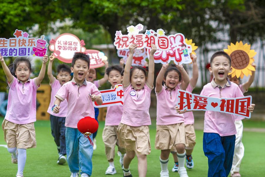 Ni?os corren con carteles festivos y de buenos deseos en un jardín infantil en la ciudad de Xinghua, en la provincia oriental china de Jiangsu, el 26 de septiembre de 2024. (Xinhua/Zhou Shegen)