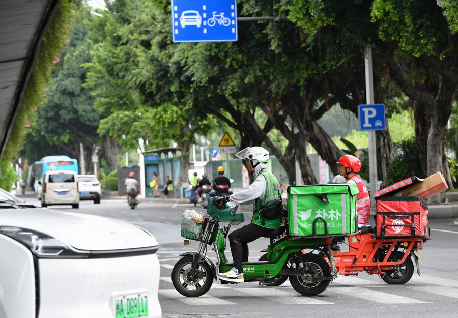 Repartidores son vistos en una calle, en Fuzhou, en la provincia de Fujian, en el sureste de China, el 30 de julio de 2023. (Xinhua/Wei Peiquan)