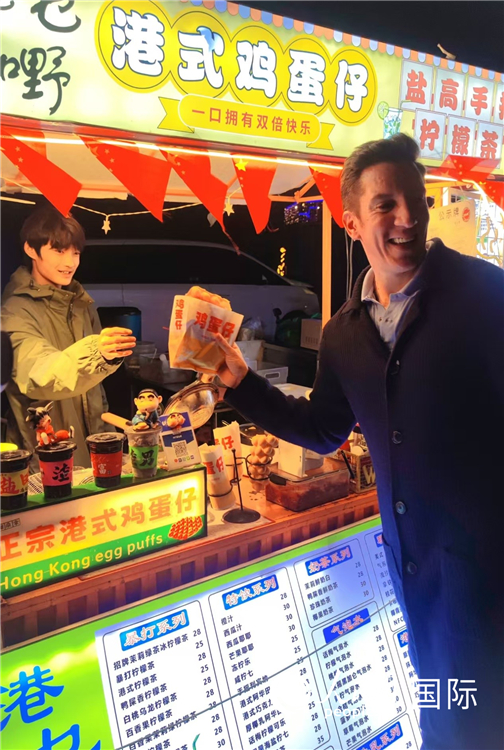 Un reportero extranjero del Diario del Pueblo digital disfruta el mercado nocturno de Yan'gang en Shenzhen, provincia de Guangdong. (Foto: Diario del Pueblo digital/ Zhang Lulu)