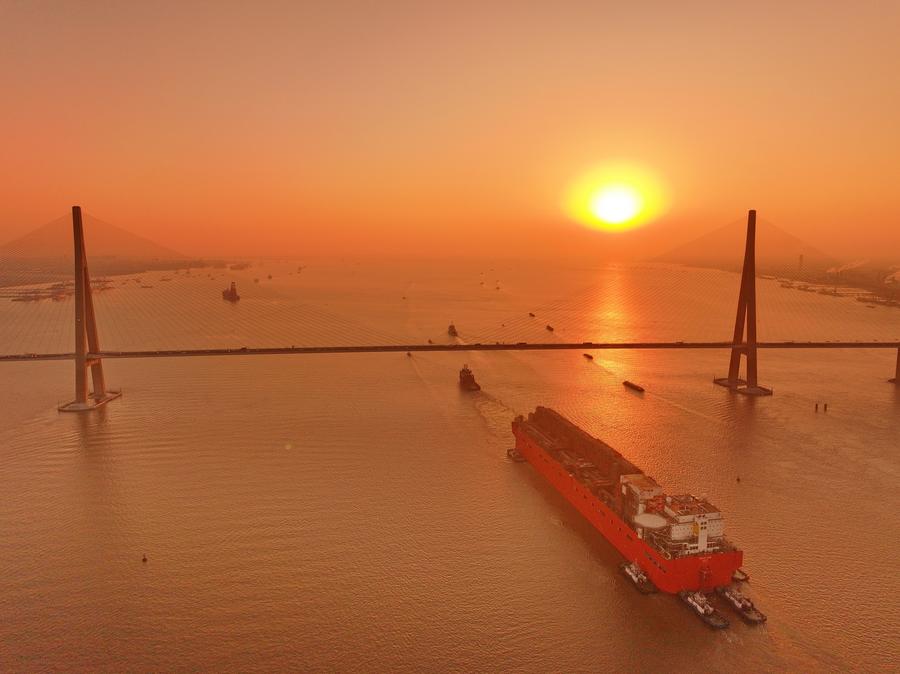 Vista aérea tomada con un dron el 9 de diciembre de 2024 del "NGUYA FLNG," una instalación flotante de gas natural licuado (GNL), siendo remolcada a través del puente Sutong (Suzhou-Nantong) sobre el río Yangtze, en la provincia de Jiangsu, en el este de China. (Xinhua/Xu Congjun) 