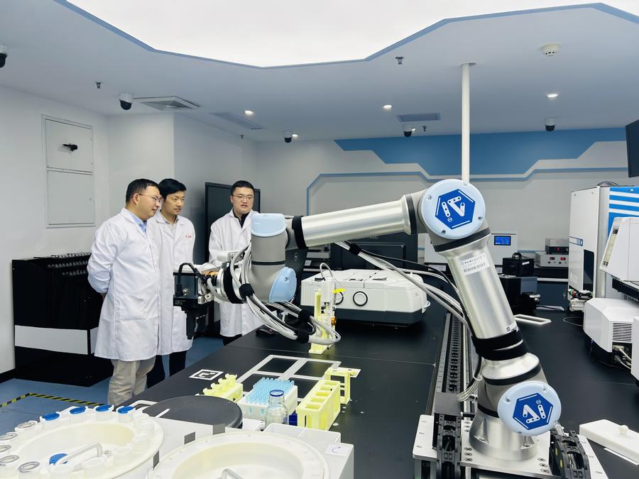 Investigadores trabajan con un robot impulsado por IA para tareas de química en la Universidad de Ciencia y Tecnología de China en Hefei, en la provincia de Anhui, en el este de China, el 10 de noviembre de 2023. (Xinhua/Zhou Chang)
