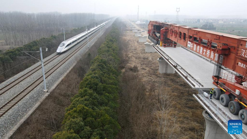 HEFEI, 23 febrero, 2025 (Xinhua) -- Vista aérea tomada con un dron el 23 de febrero de 2025 del sitio de instalación de vigas cajón de un ferrocarril de alta velocidad que une Shanghai, Nanjing de la provincia de Jiangsu y Hefei de la provincia de Anhui, en el este de China. El ferrocarril es parte de la red ferroviaria de alta velocidad de China que se centra en ocho líneas verticales principales que unen el norte y el sur y ocho líneas horizontales que conectan el este y el oeste. (Xinhua/Zhang Biying)