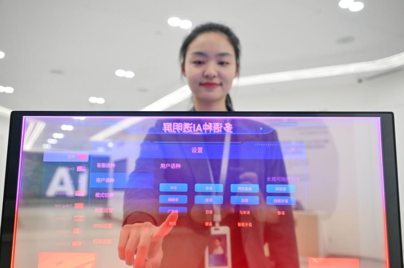 Una empleada muestra un sistema de traducción multilingüe en tiempo real con inteligencia artificial y pantalla transparente, en la sucursal de iFLYTEK en Tianjin, en el norte de China, el 18 de abril de 2025. (Xinhua/Sun Fanyue)