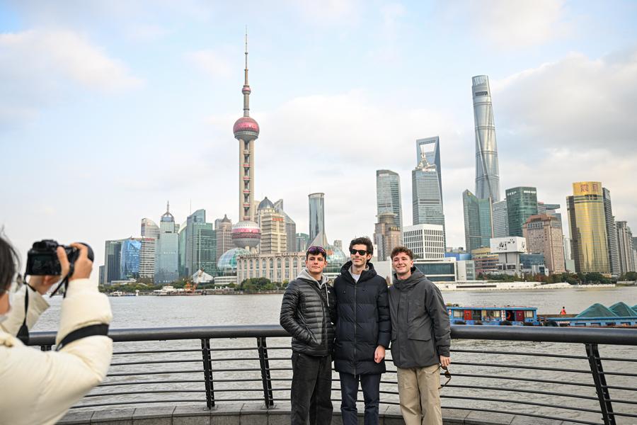 Turistas extranjeros se toman fotos en el Bund, en la metrópoli oriental china de Shanghai, el 4 de diciembre de 2024.  (Xinhua/Chen Haoming) 