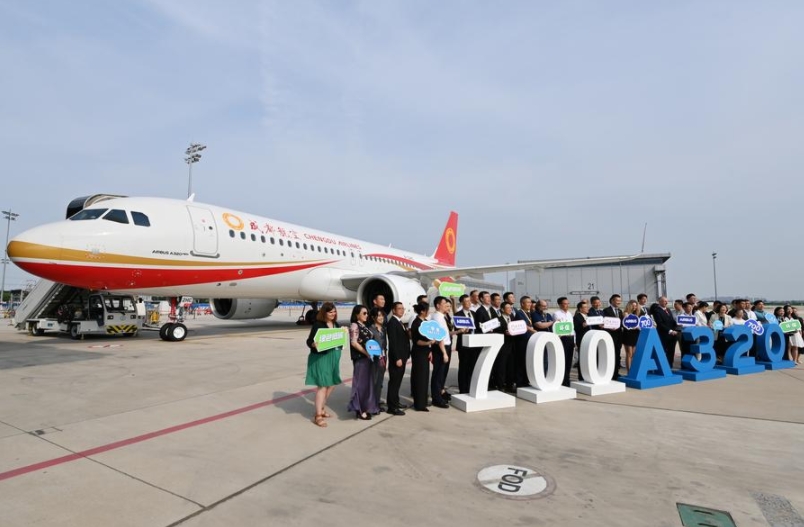 Los invitados a la ceremonia de entrega a Chengdu Airlines del avión número 700 de la familia A320, ensamblado por Airbus Tianjin, posan para una foto delante de la aeronave, en Tianjin, en el norte de China, el 8 de julio de 2024. (Xinhua/Li Ran)