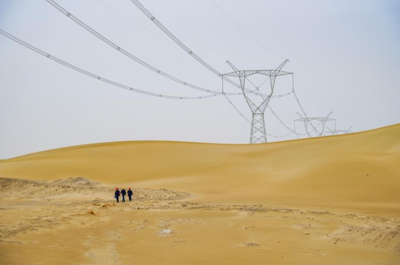 Operarios patrullan a lo largo de la línea eléctrica de la red de 750 kilovoltios (kV) alrededor de la cuenca del Tarim en el distrito de Yuli, región autónoma uygur de Xinjiang, en el noroeste de China, el 27 de abril de 2024. (Xinhua/Xu Hongyan)